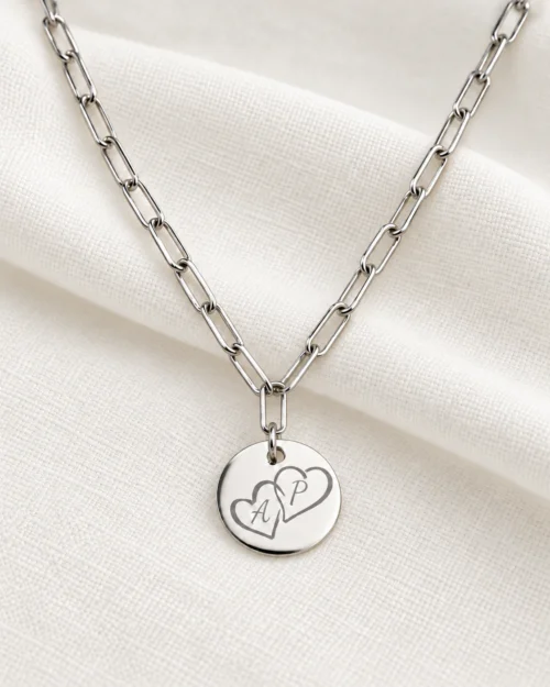 Collar Link de cadena de eslabones rectangulares en plata de ley 925 con colgante redondo personalizable de 15 mm, grabado con dos corazones e iniciales, sobre tela color crema