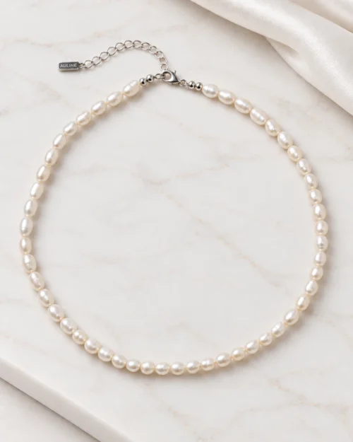 Collar Maia de perlas naturales ovaladas con cierre y alargador de plata de ley 925, sobre base de mármol color crema con tela satinad