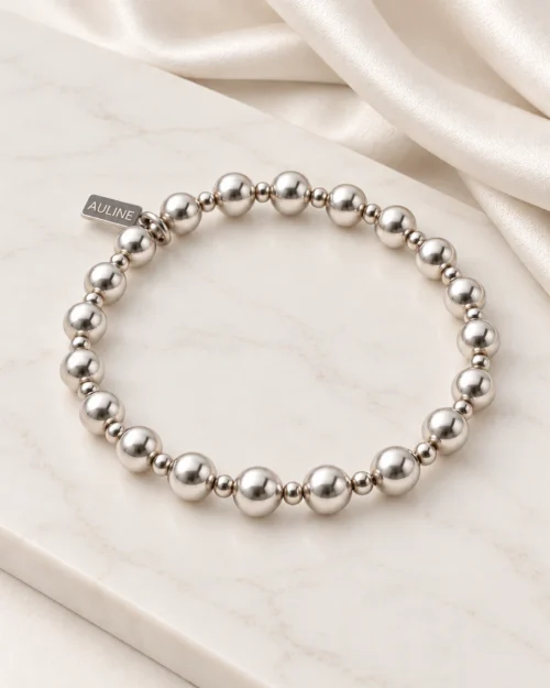 Pulsera Dúo de bolas con relieve en plata de ley 925, sobre base de mármol color crema con tela satinada